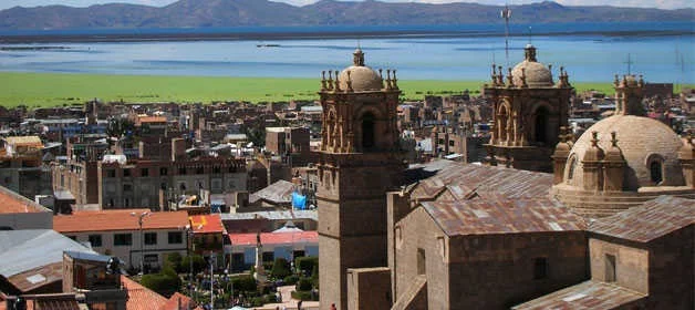 Vista panorámica de la ciudad de Puno con las torres de la Catedral Basílica de San Carlos Borromeo y el Lago Titicaca al fondo